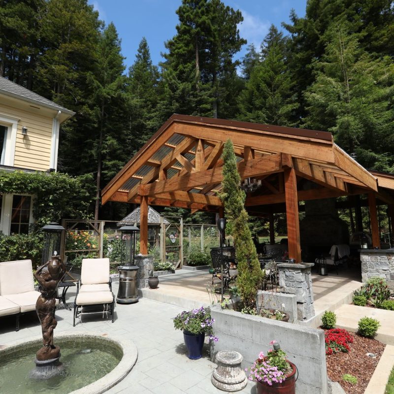 Eureka, California homeowners' desire for an outdoor fireplace quickly expanded into an outdoor kitchen, living, and entertainment space, capped by a stunning, custom-built redwood timber pergola.